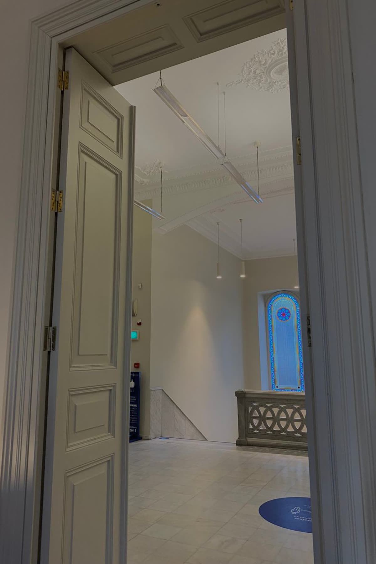 An open interior door seen from the hallway, with a staircase visible through it in the room beyond.